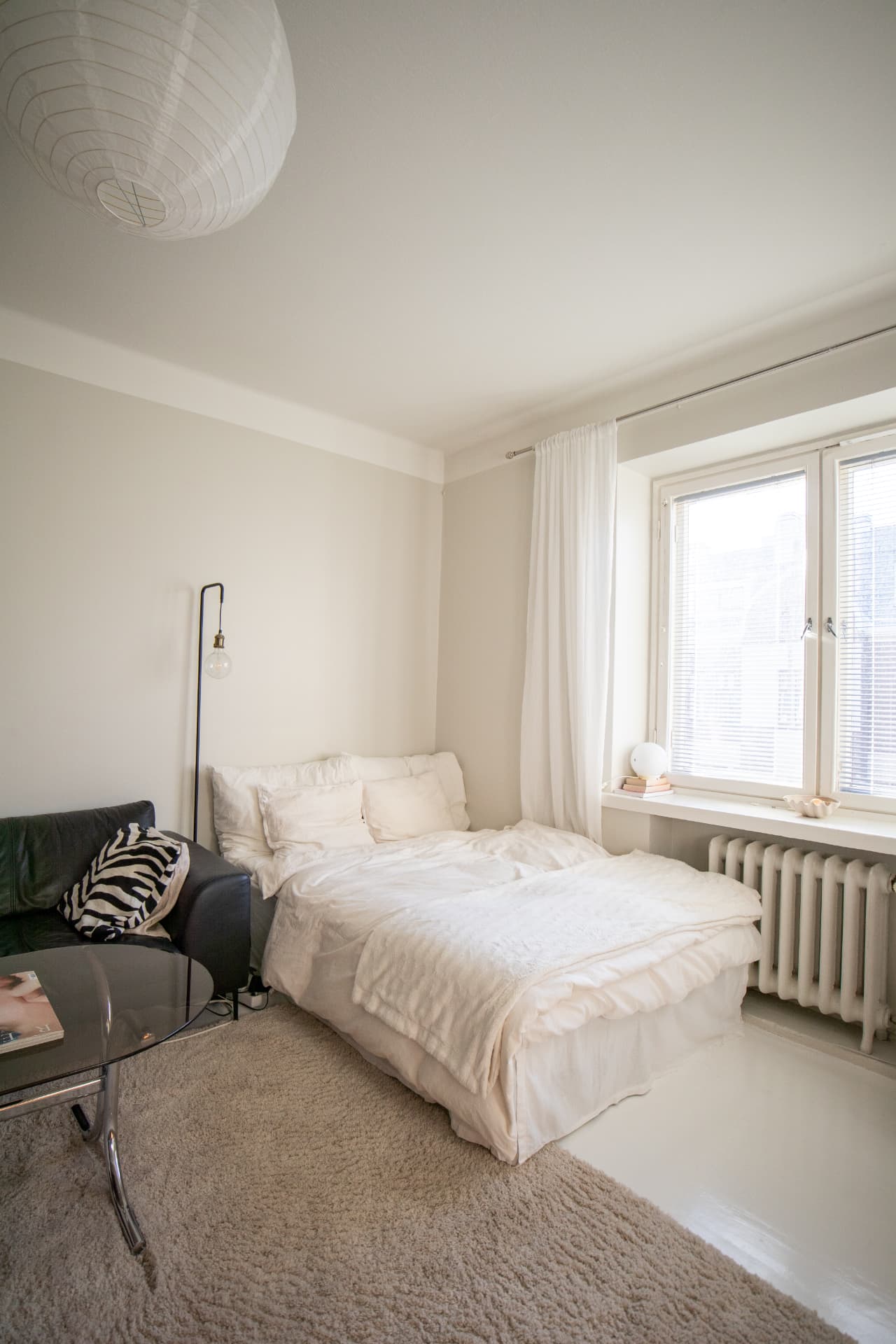 Soft white bedroom with paper lantern and floor lamp