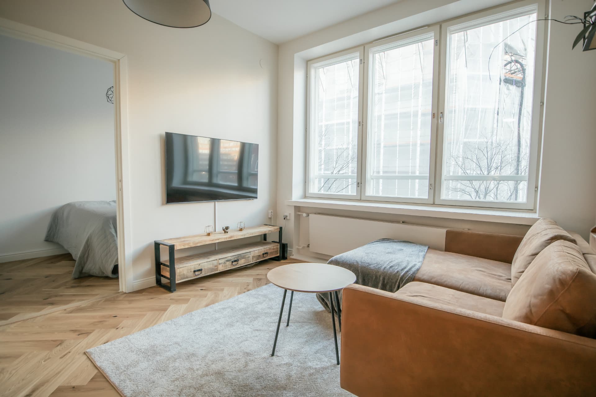 Living room with leather sofa and tall windows in a Helsinki rental